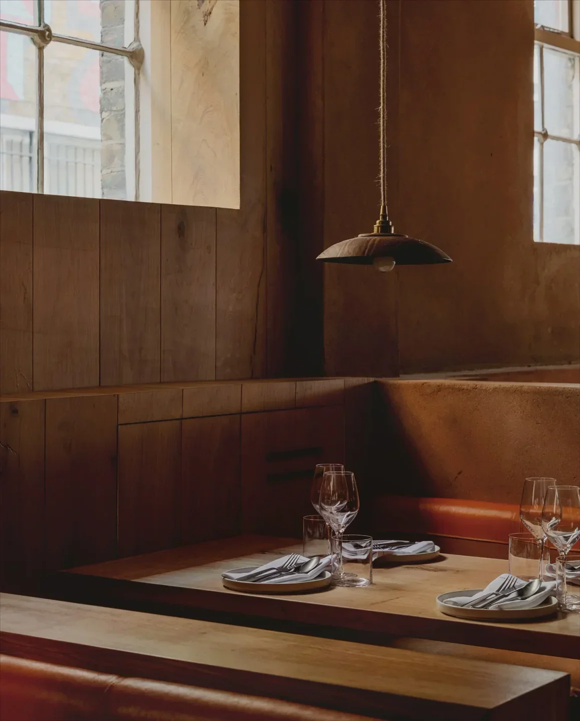 Cozy dining area at Manteca restaurant in London, with wooden tables and warm lighting