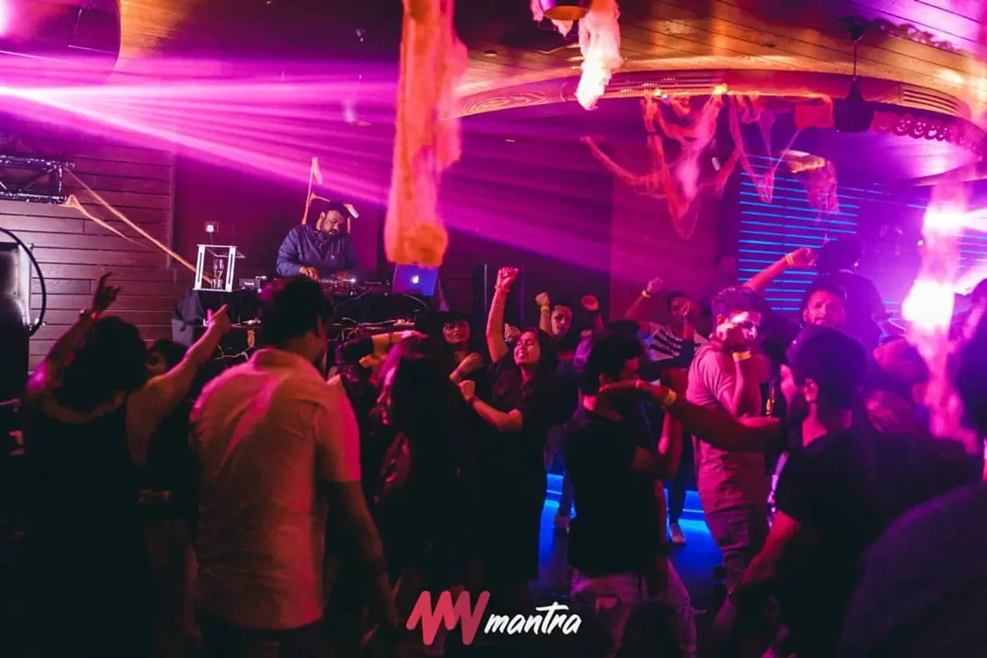 Energetic crowd enjoying the night at Mantra Night in Abu Dhabi, with DJ and lights.