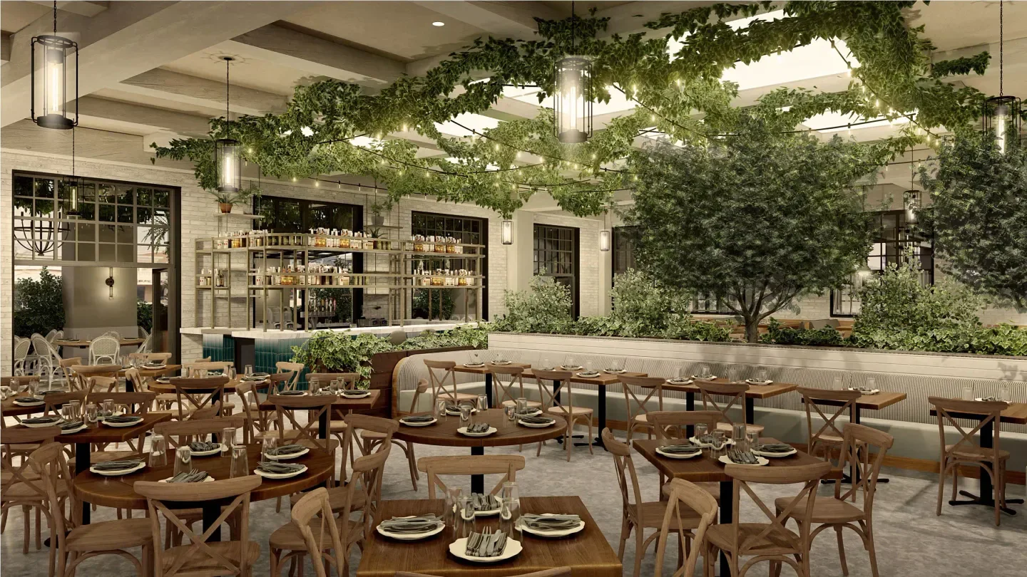 Inside Maple & Ash restaurant in Phoenix with stylish decor and green foliage.