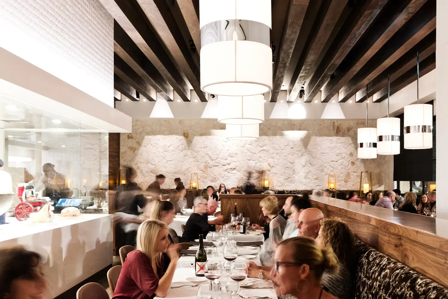 Interior dining scene at Marché Moderne restaurant in Orange County, with hanging lights and guests.