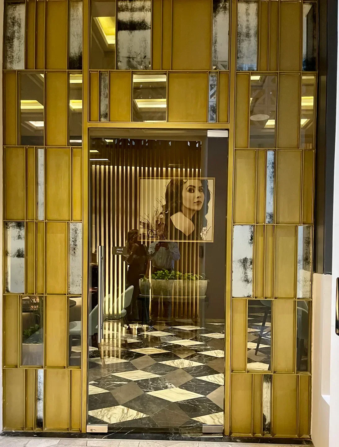 Entrance of Maria Dolores restaurant in Cancun, featuring elegant gold and mirrored details