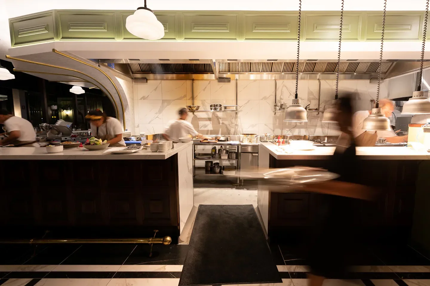 Busy kitchen scene at Market Bistro on the Sunshine Coast, chefs at work and staff serving.