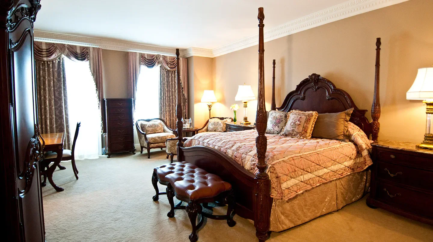 Elegant bedroom at Market Pavilion Hotel in Charleston with four-poster bed and classic decor.