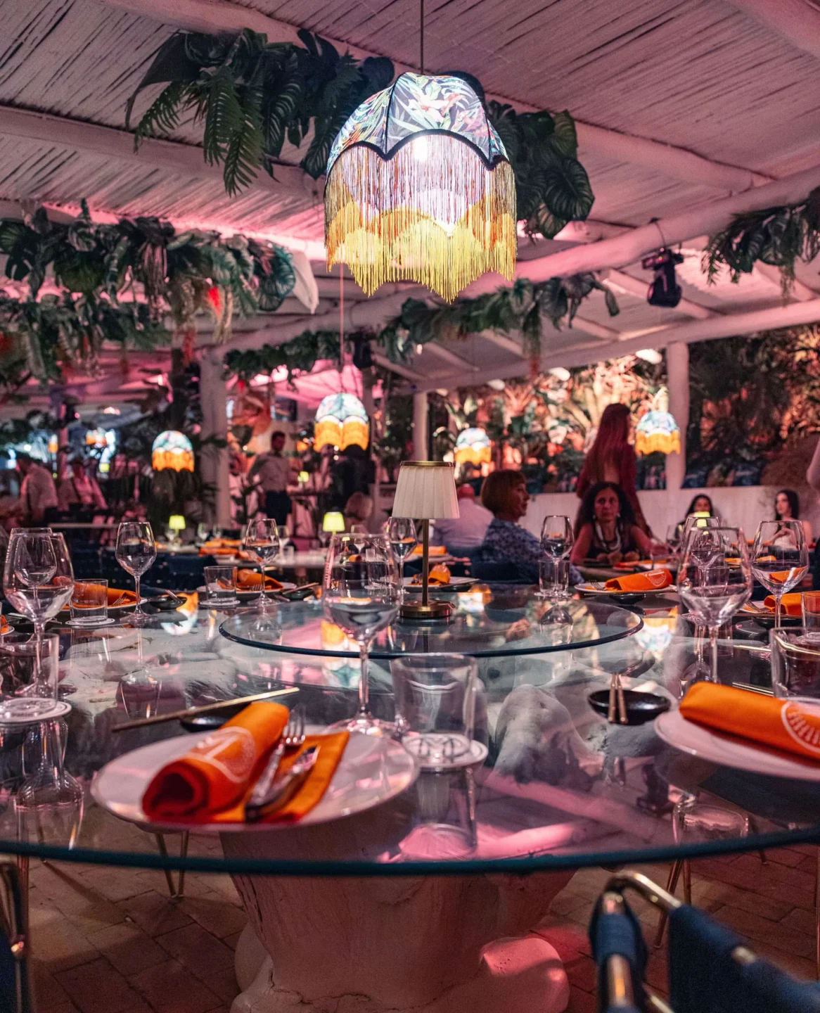 Tropical-themed dining room at Marro restaurant in Porto Cervo, set for dinner with lush greenery and ambient lighting.