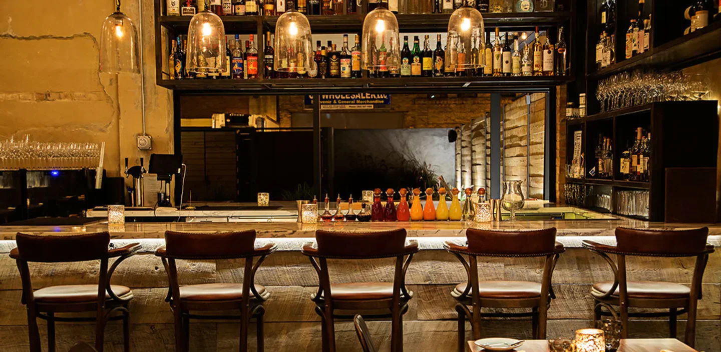 Cozy bar at Masseria restaurant in Washington, with bottles and inviting ambiance.