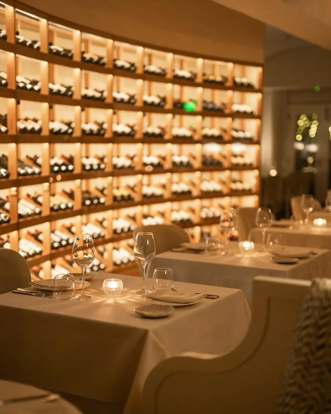 Elegant dining at Masso restaurant in Manama, featuring a beautiful wine display.