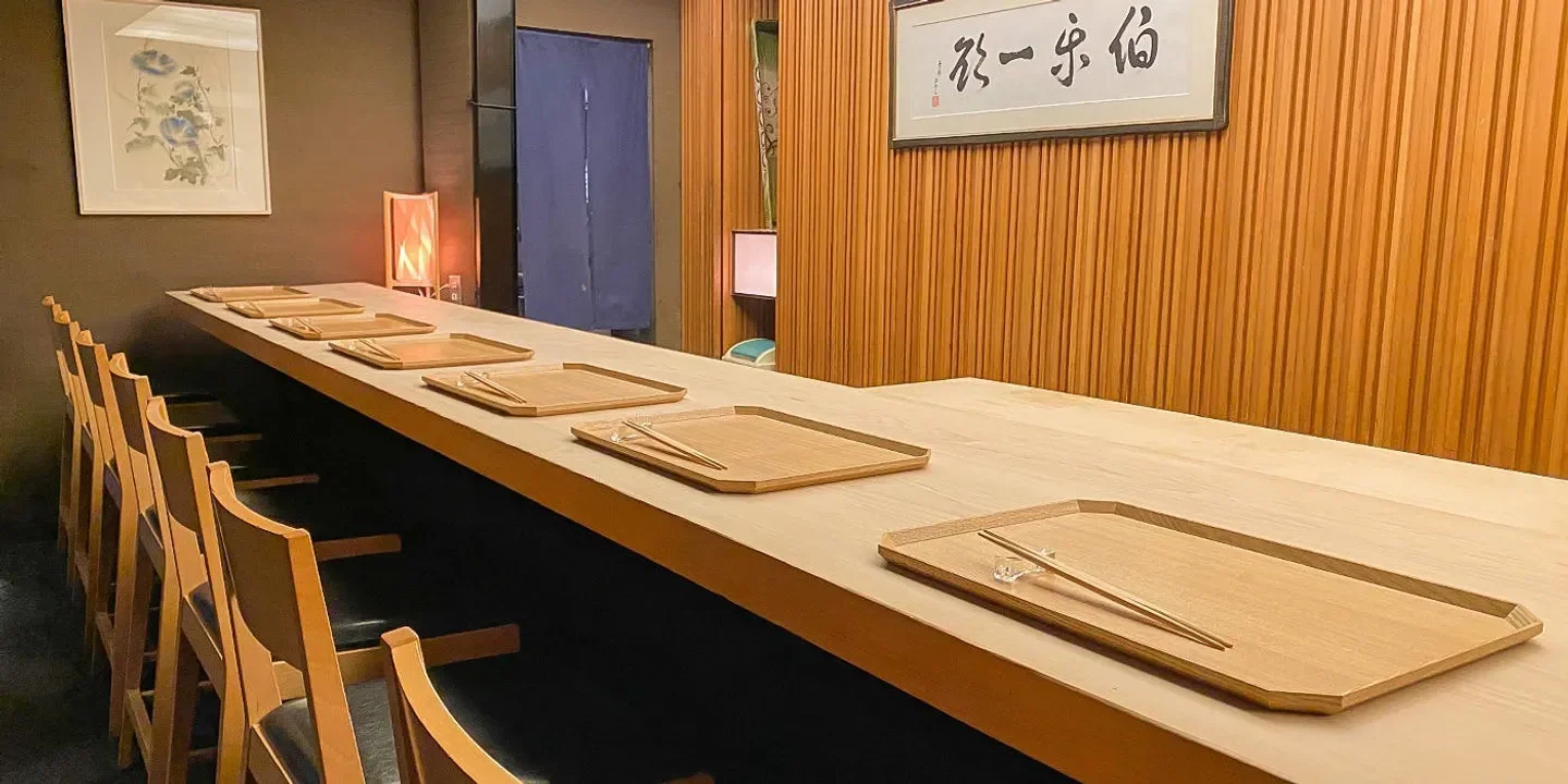 Elegant dining space at Masuda restaurant in Osaka, showcasing wooden table settings.
