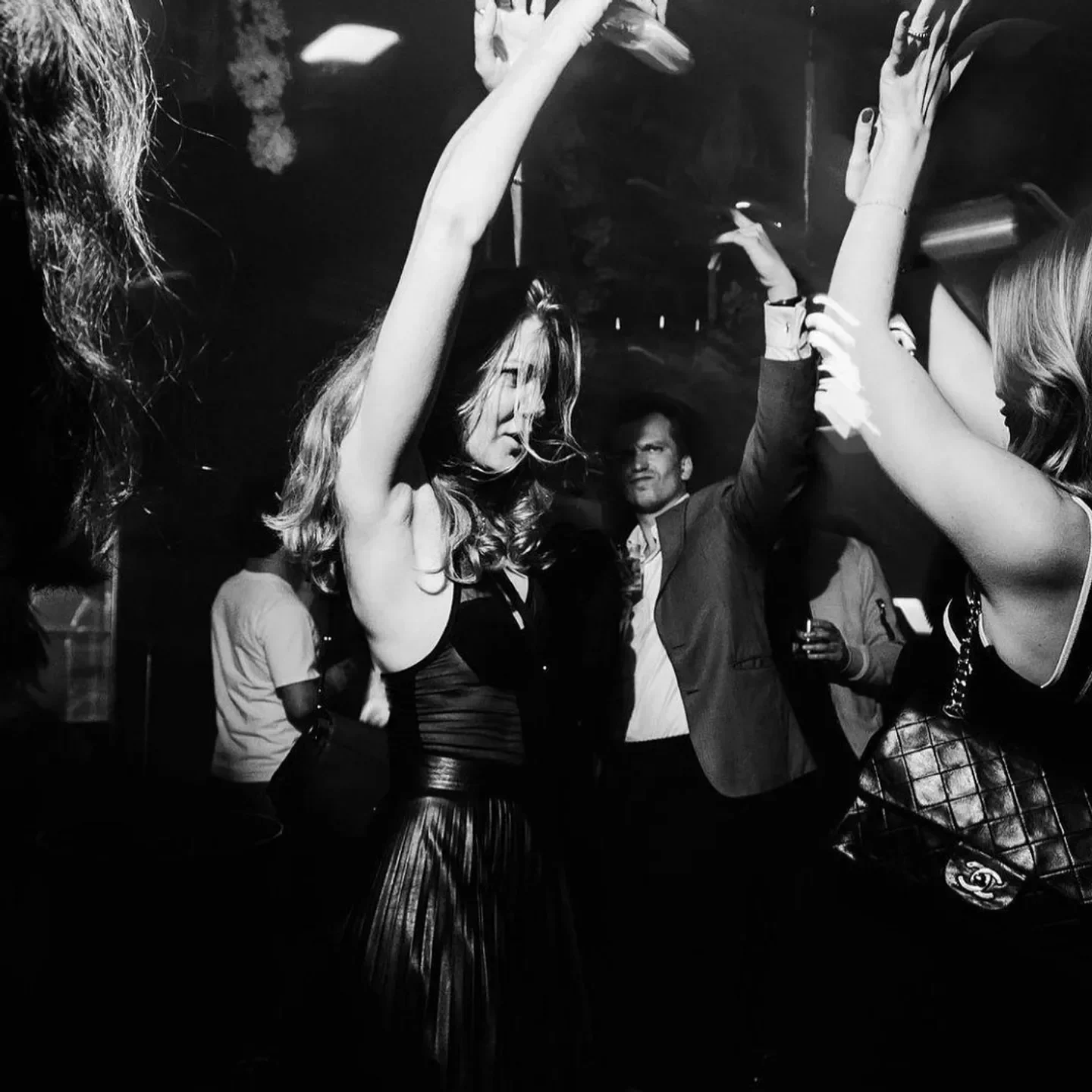 Dancing at Matignon nightclub in Paris, lively party atmosphere with raised arms.