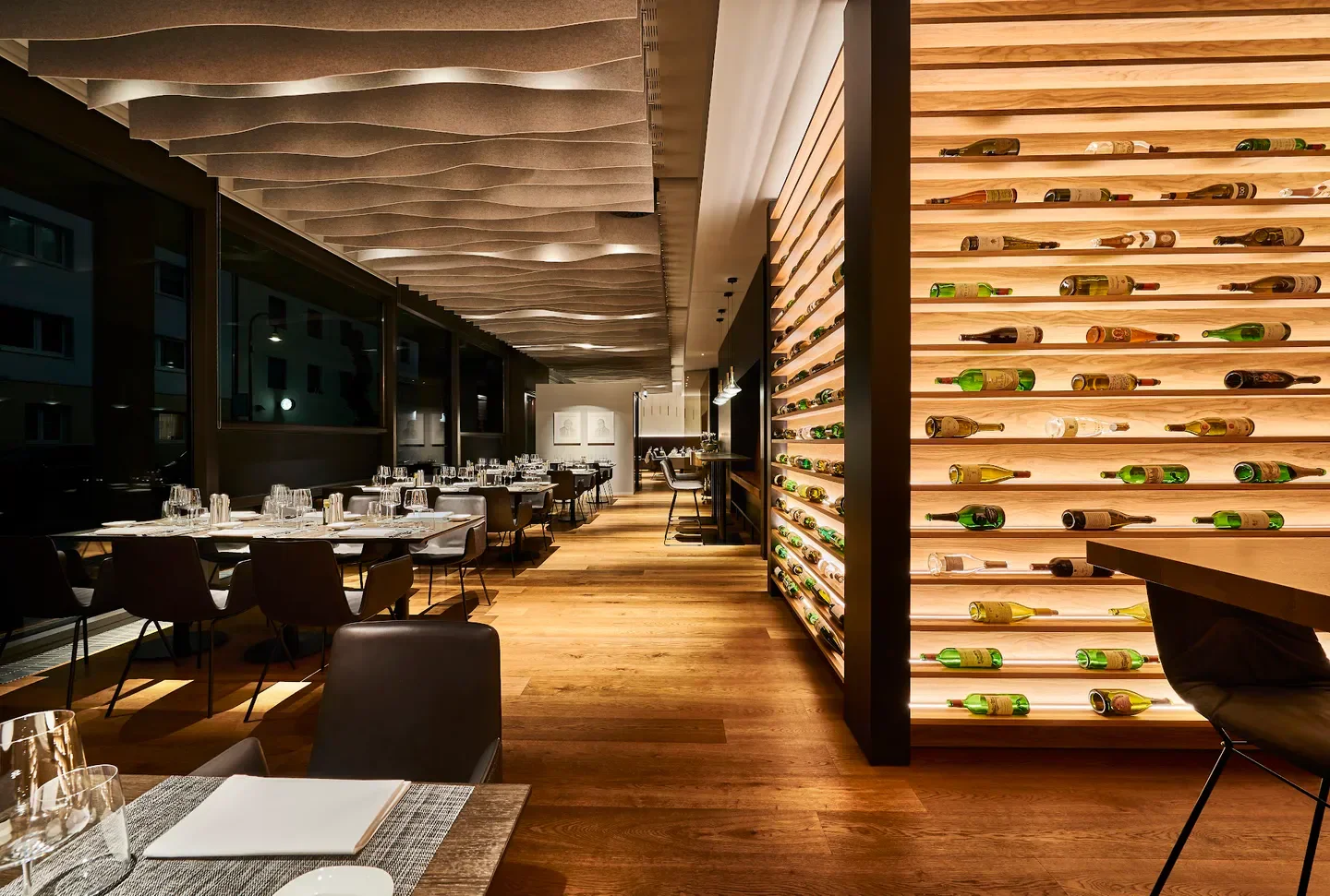 Interior of maximilian lorenz restaurant in Cologne with wine display and dining tables.