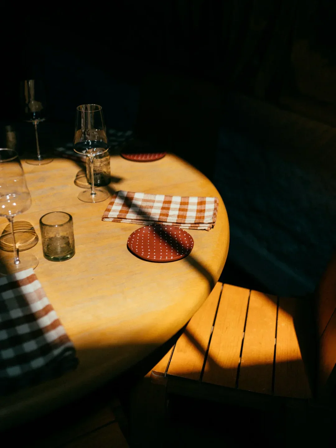 Elegant table setting at Máximo Bistrot in Mexico City, featuring glassware and checkered napkins.
