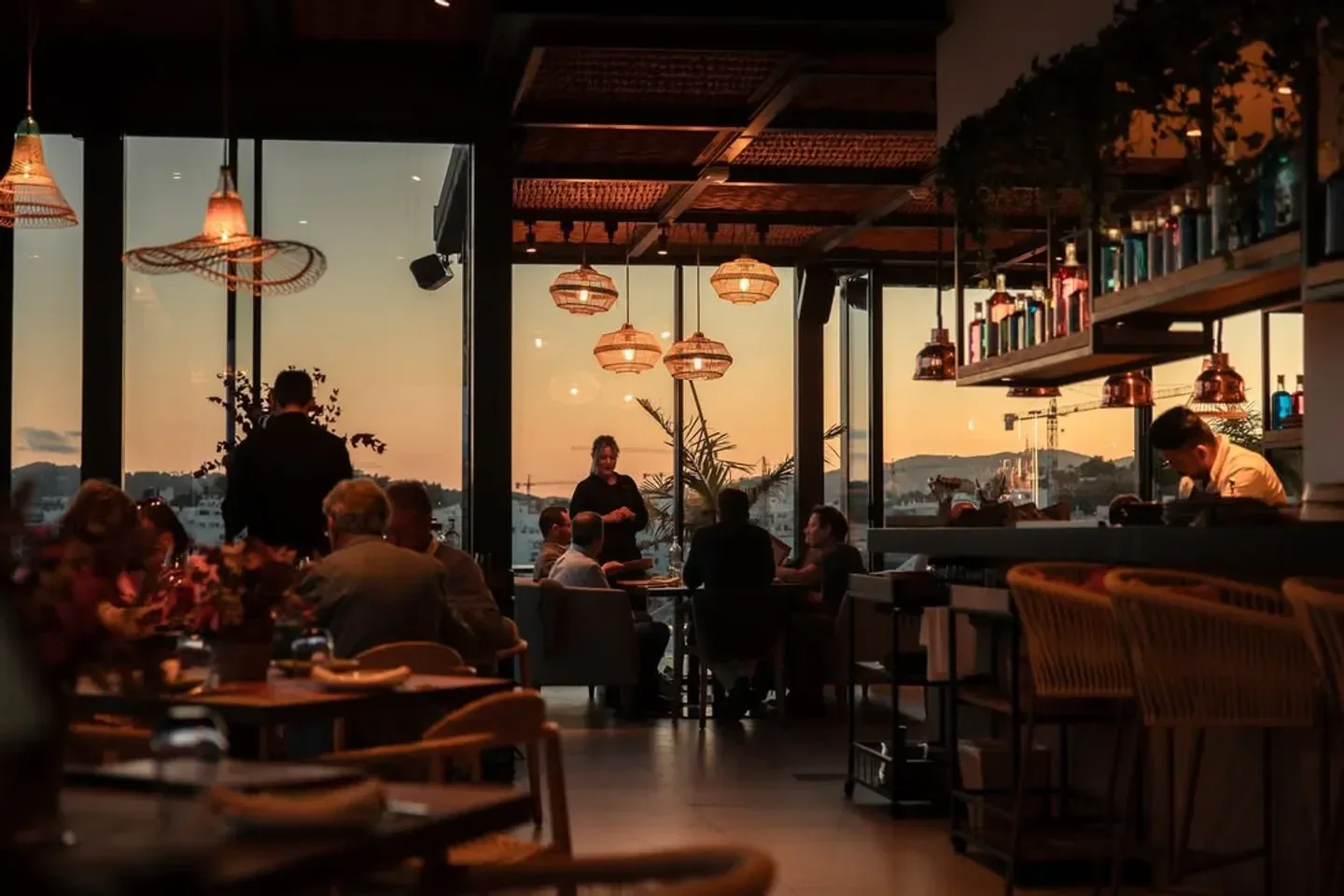 Sunset view from Maymanta restaurant in Ibiza, featuring stylish interior and dining guests.