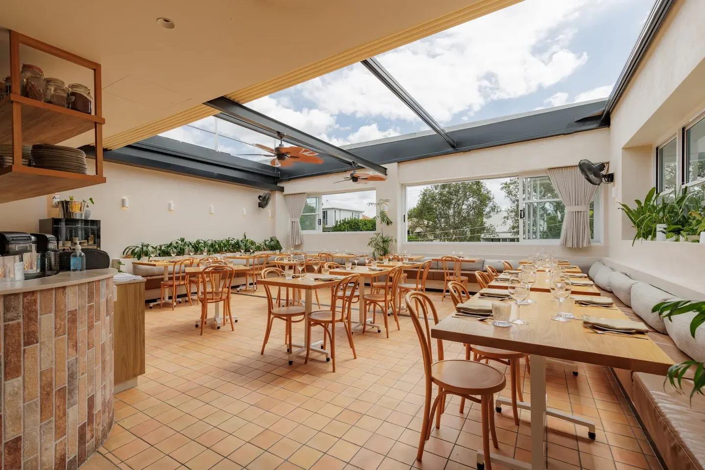 Open-air dining room at Melrose Restaurant in Brisbane, featuring tables and chairs.