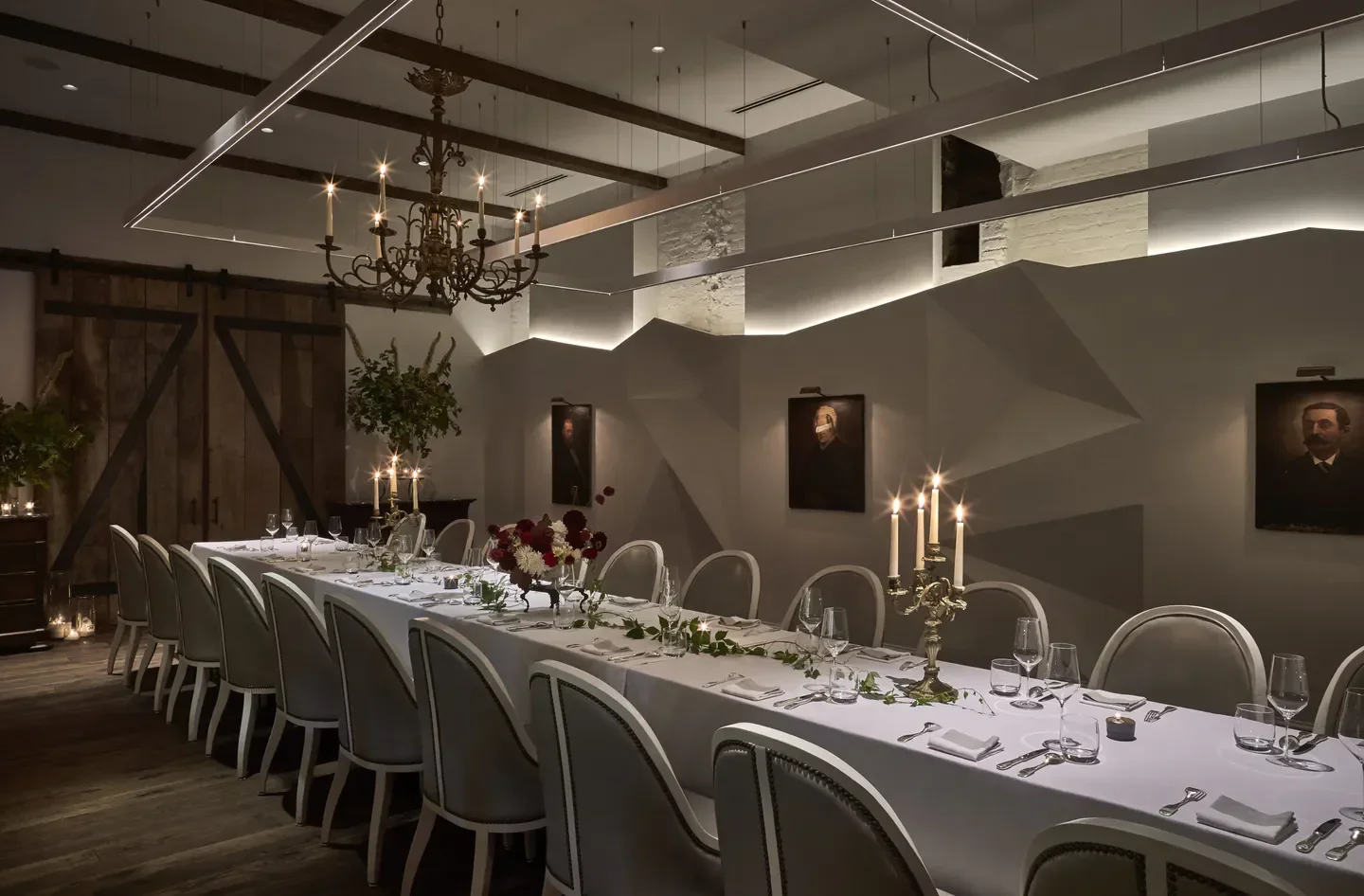 Elegant dining room at Métier, Washington, with long table and antique chandelier