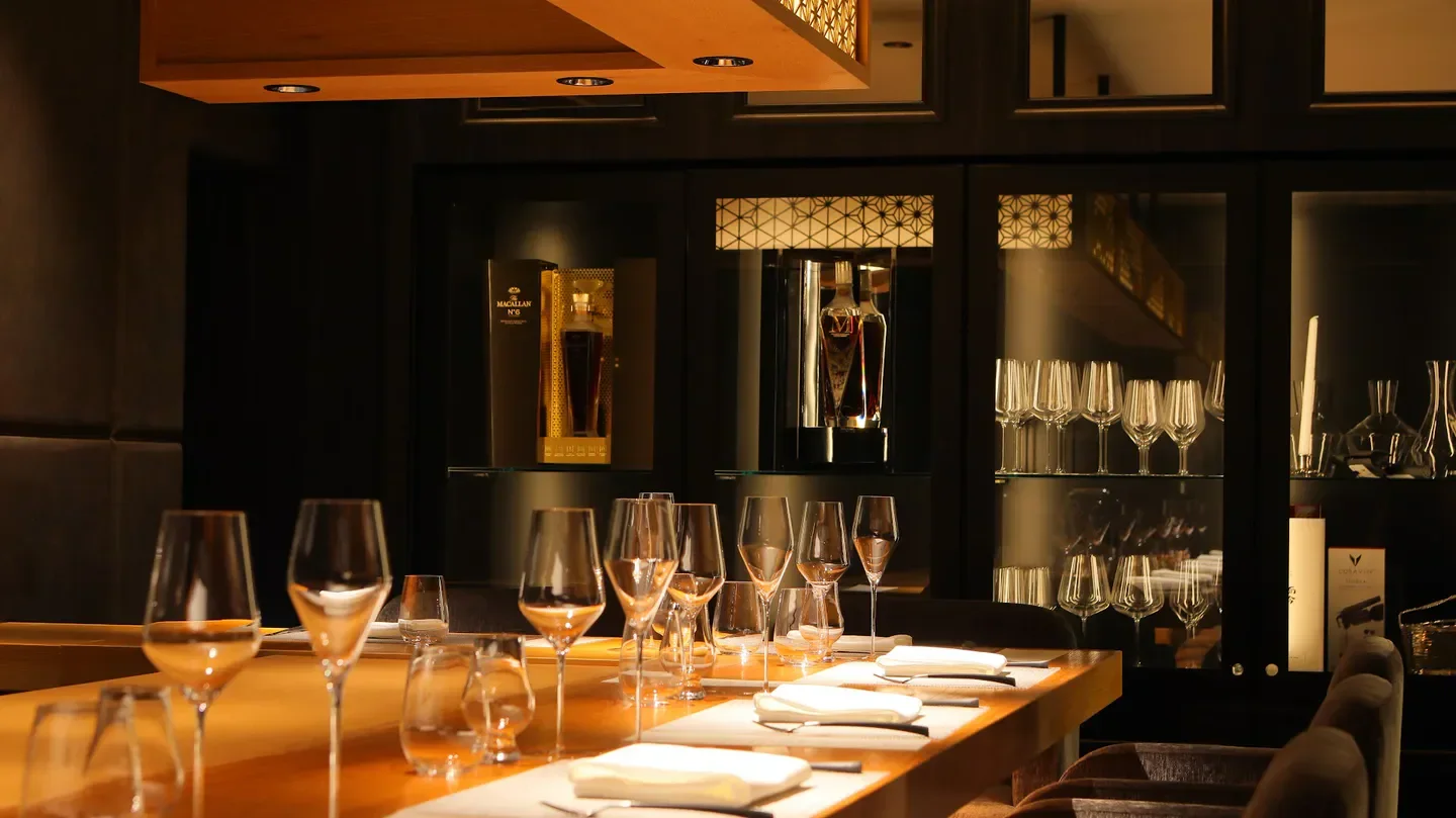 Elegant dining at Mētis Roppongi restaurant in Tokyo, showcasing glassware and spirits