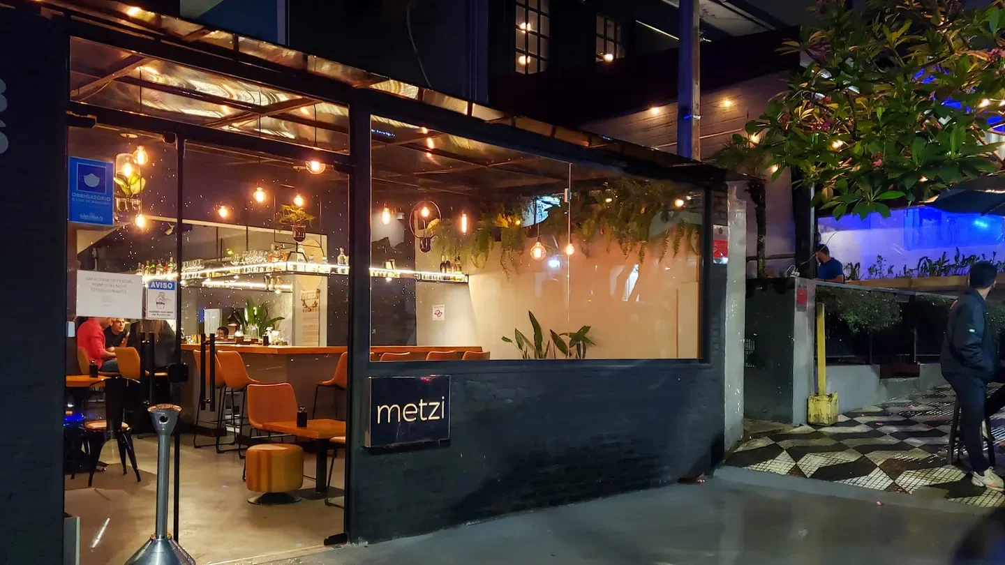 Exterior view of Metzi restaurant in Sao Paulo at night with warm lighting.