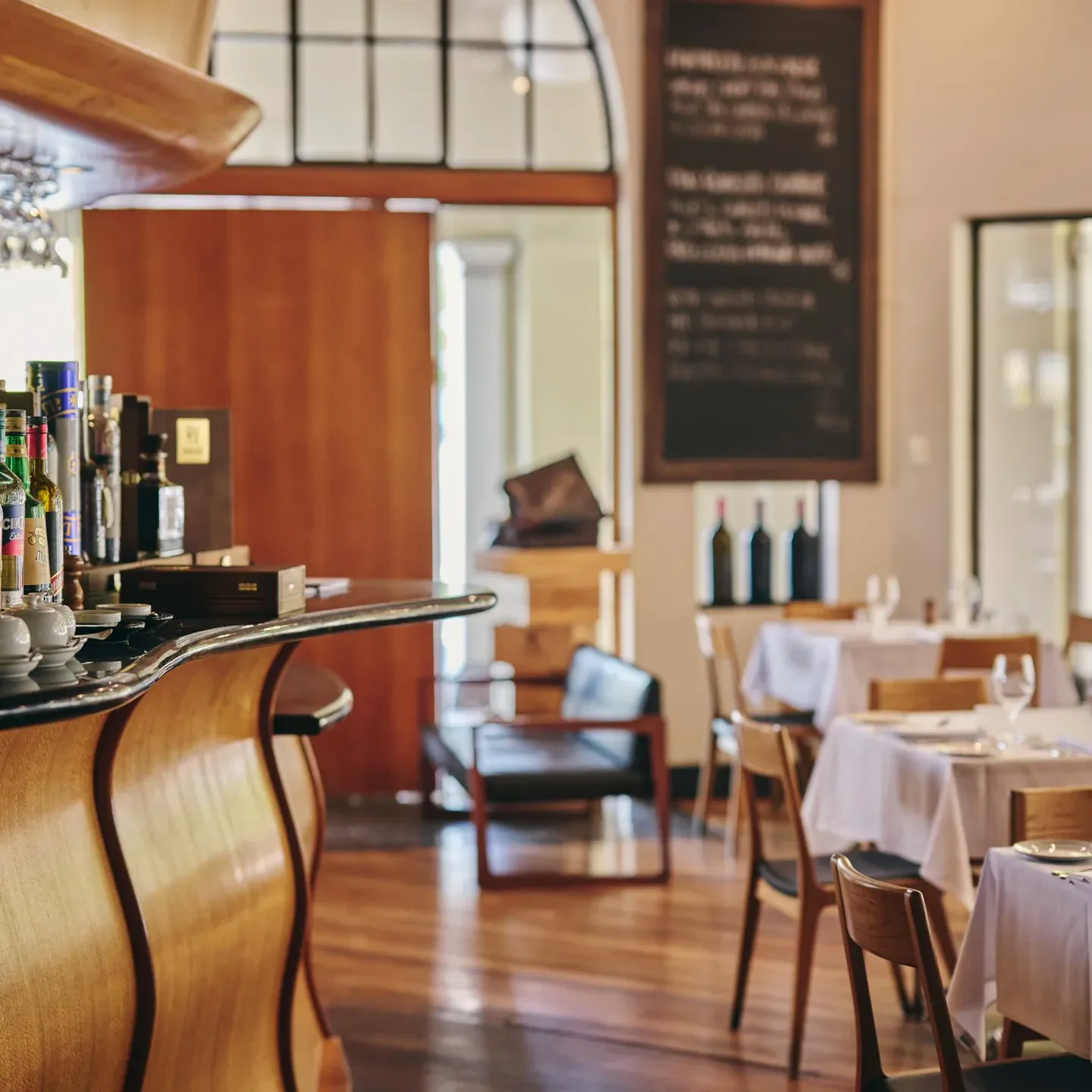 Interior of Mezzalira restaurant in Canberra, featuring a wooden bar and dining tables.