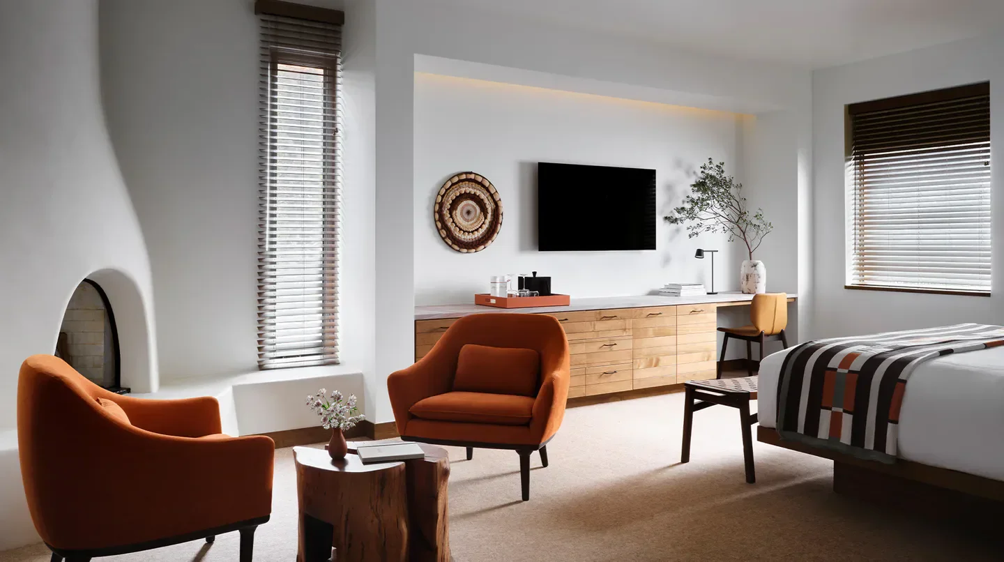 Cozy room interior at Mii amo hotel in Sedona with fireplace and orange chairs.