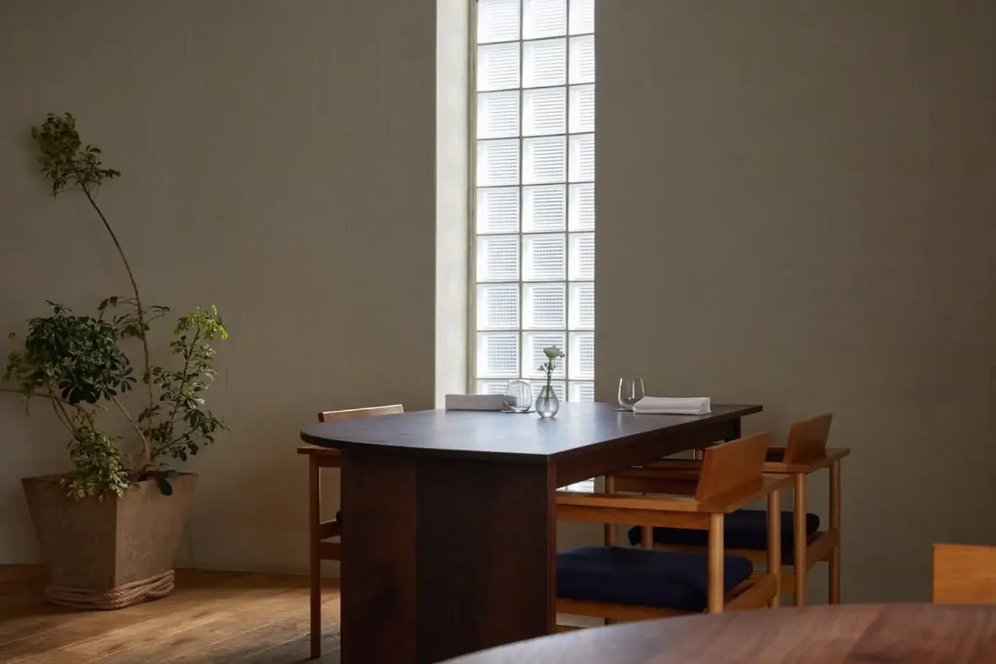 Interior dining at Mingles restaurant in Seoul, with wooden furniture and a glass block window