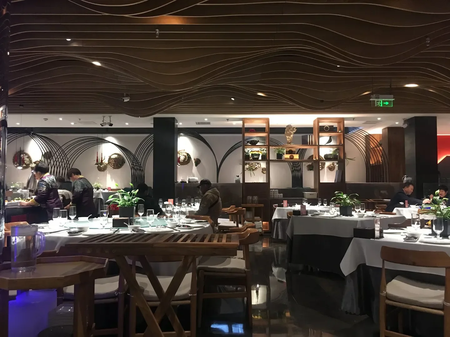 Elegant interior of Mio restaurant in Beijing, with tables set and decorative ceiling