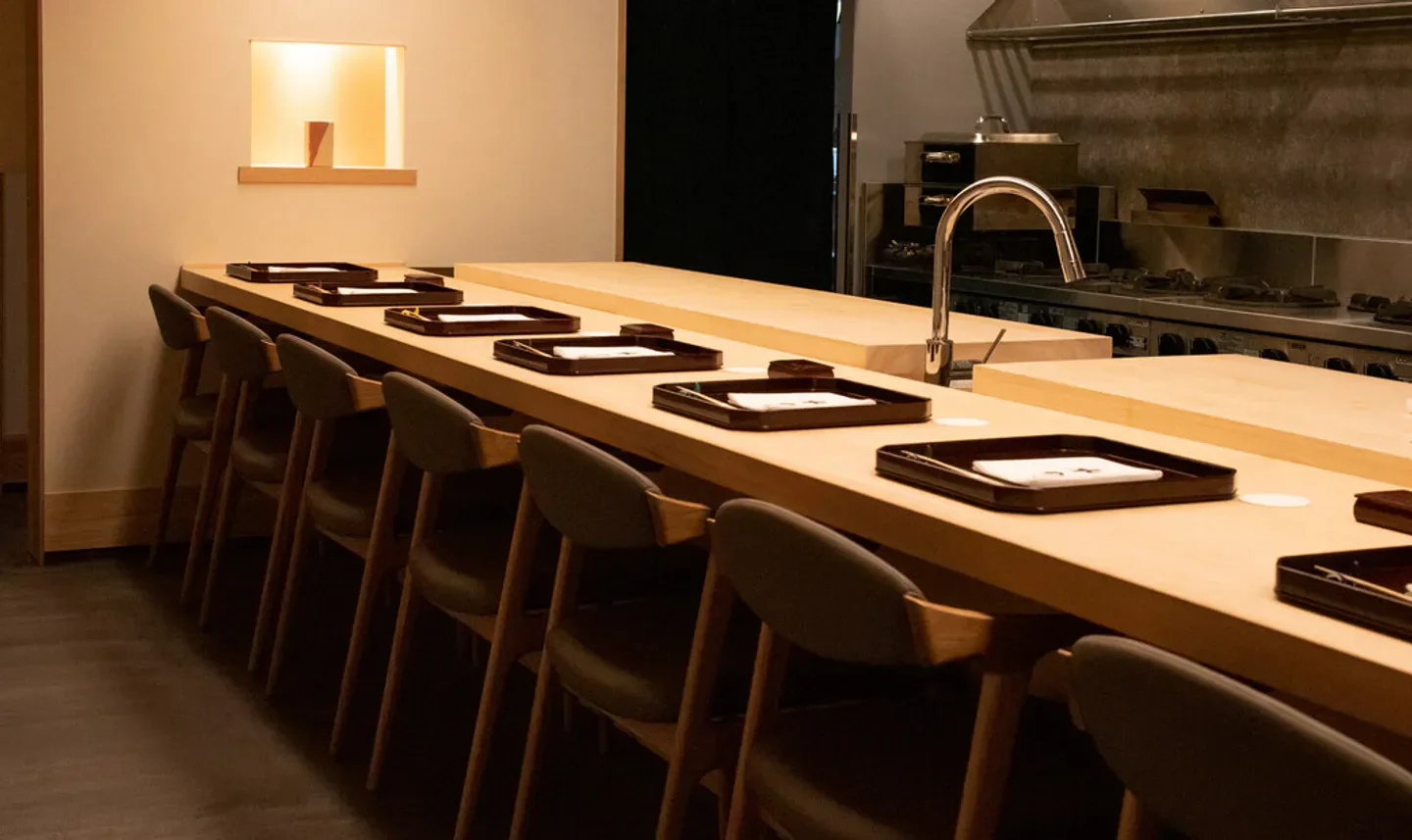 Interior of Mizuno restaurant in Kyoto: wooden bar with seating and culinary preparation area.