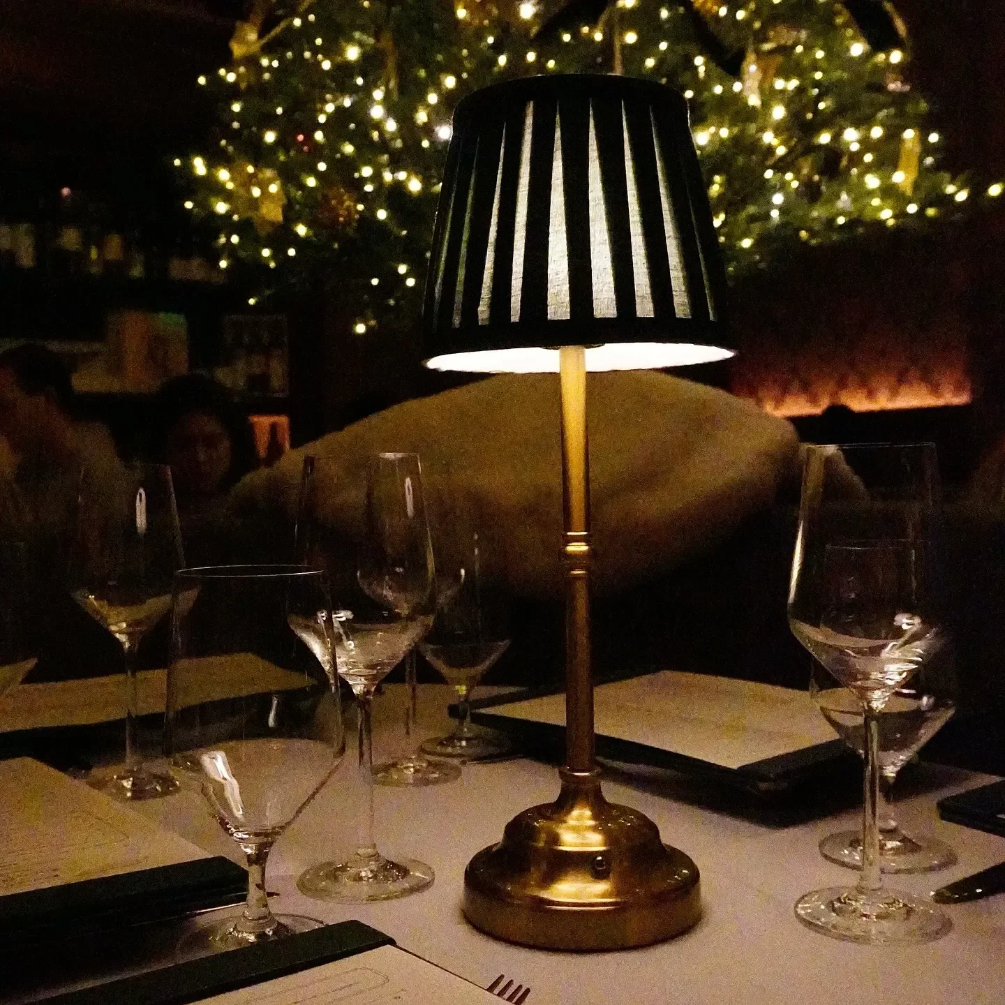 Elegant dining at MŌLÌ restaurant in Greenwich, with wine glasses and table lamp.