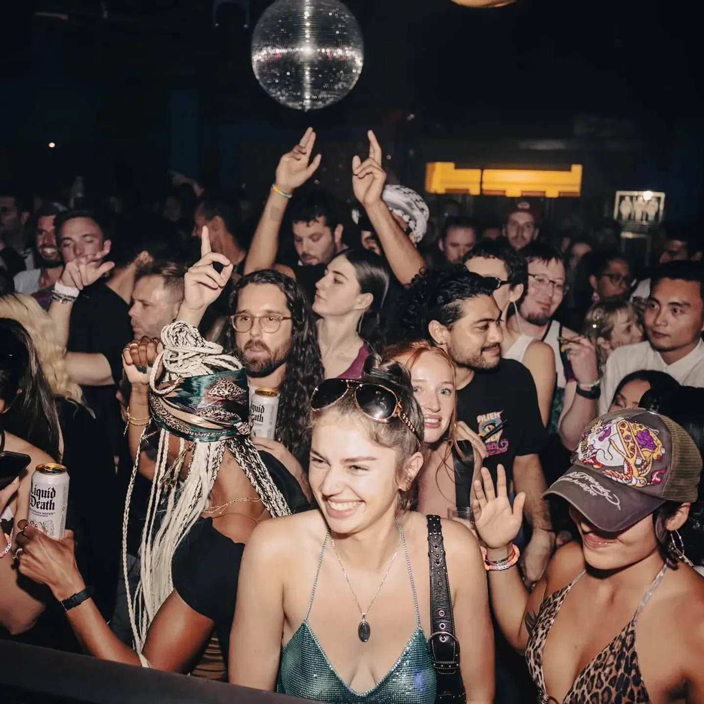 Energetic crowd dancing at Monarch nightclub in San Francisco, with disco ball overhead.