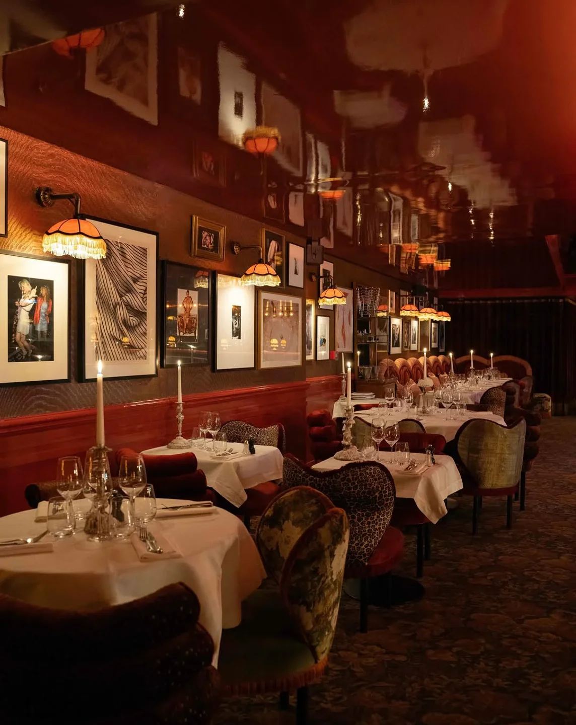 Mondaine de Pariso restaurant interior featuring candlelit tables, artwork, and plush seating in the city.