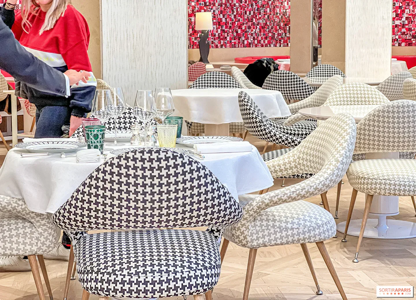 Interior of Monsieur Dior restaurant in Paris, featuring stylish patterned chairs and tables.