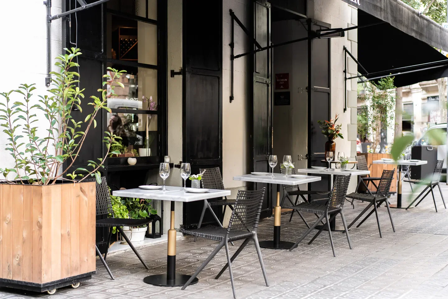 Outdoor seating at Mont Bar in Barcelona, featuring stylish tables and chairs on the patio.