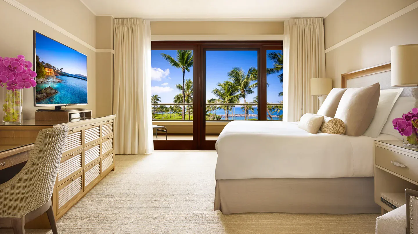 Luxury bedroom at Montage Kapalua Bay, Maui, with ocean view and palm trees.