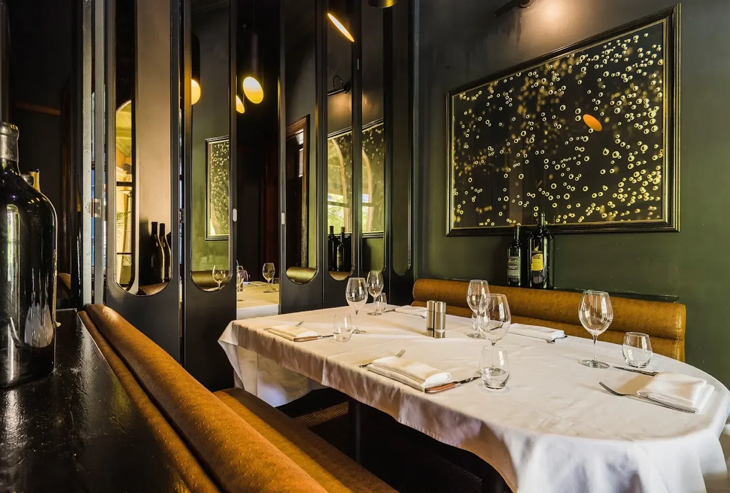 Elegant interior dining at Moo Moo Brisbane, featuring mirrors and a framed artwork, Brisbane.