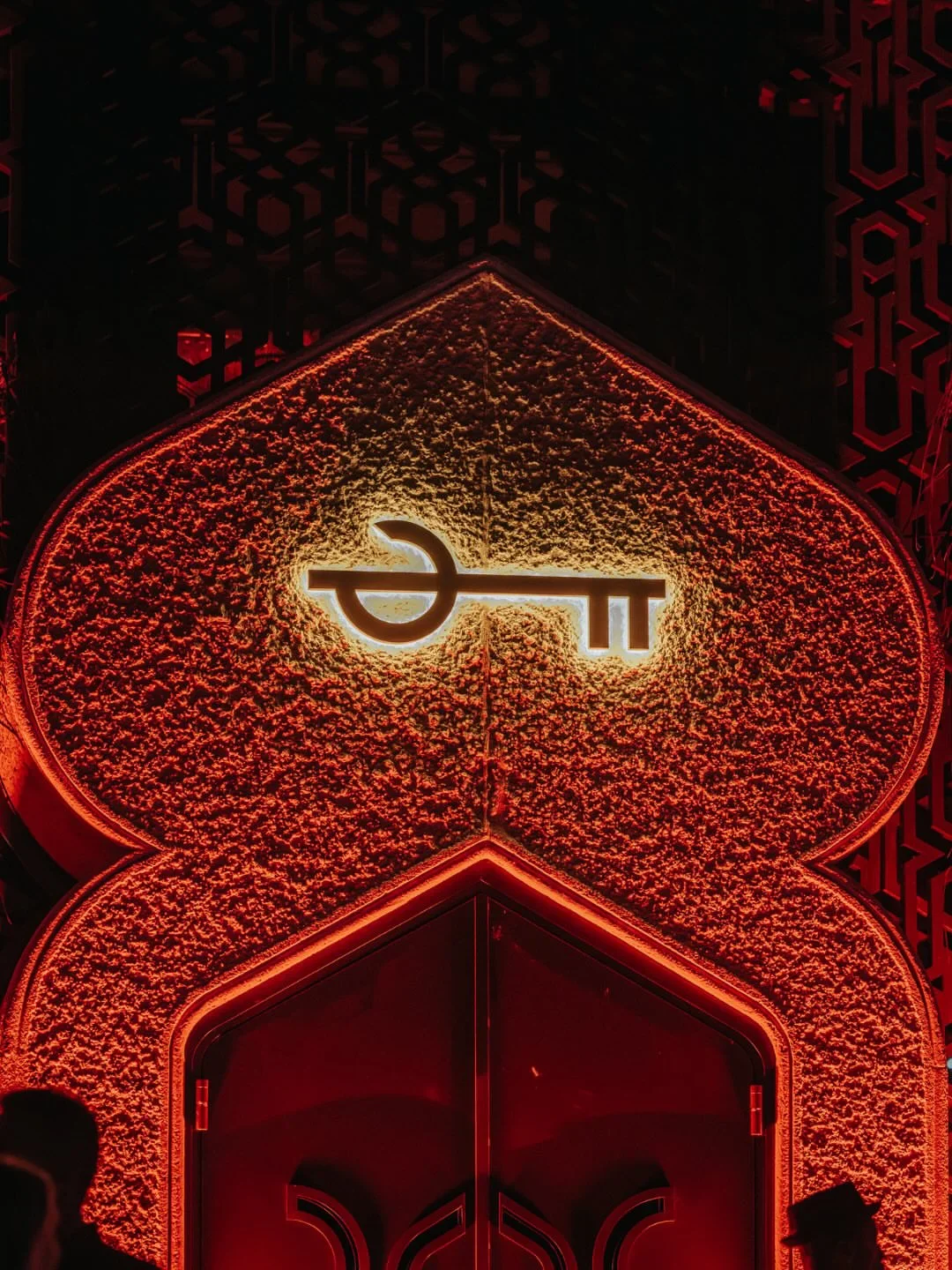Motel Particulier entrance glowing key symbol invites guests into the nightclub ambiance in the city.