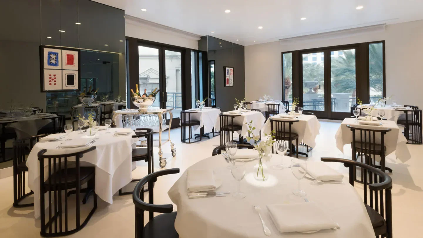 Elegant dining room interior at Mr Chow Las Vegas restaurant with white tablecloths.