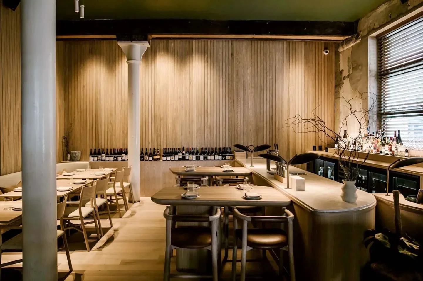 Interior of Mr. Morris restaurant in Auckland with wooden paneling, tables and bar.