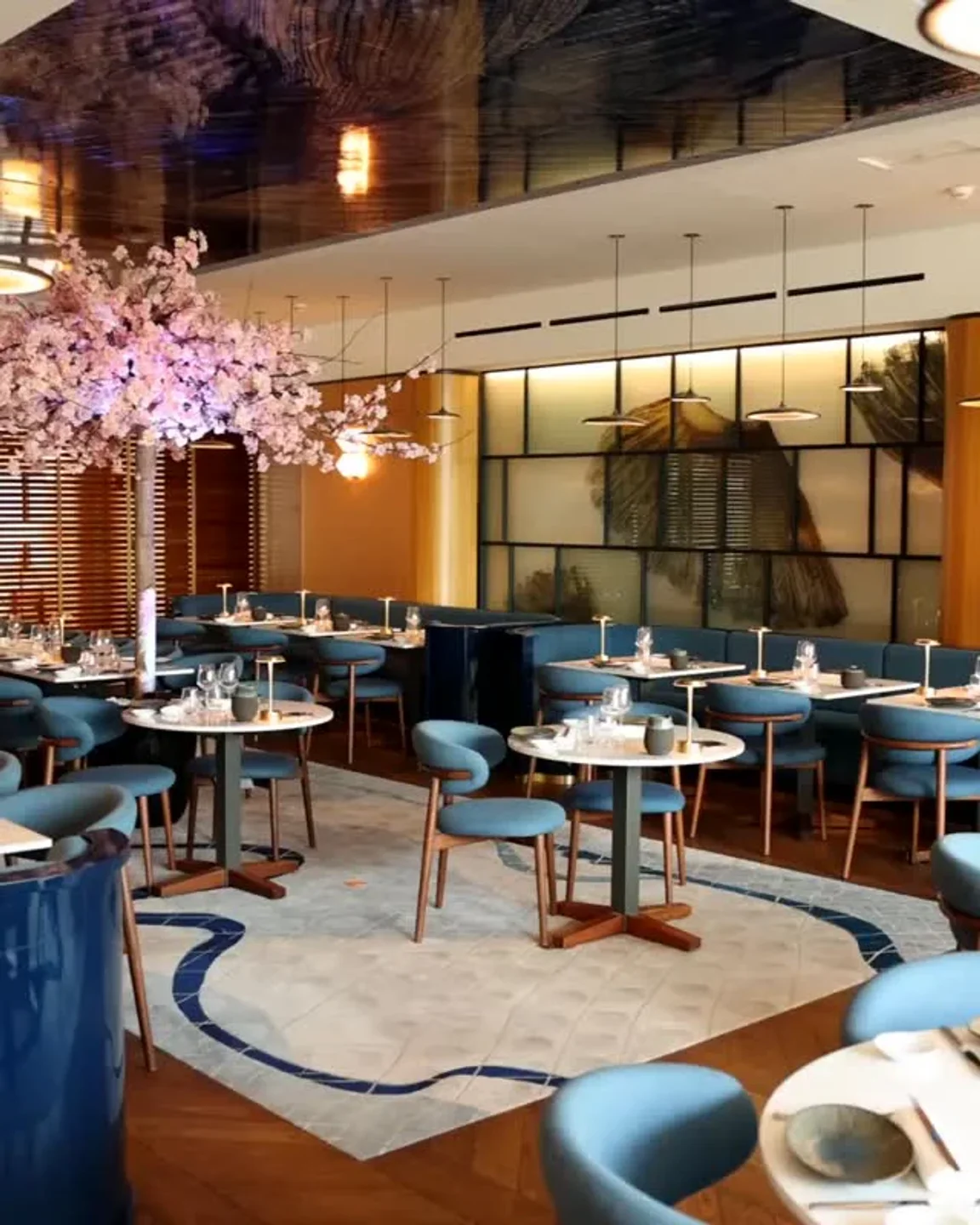 Mr. Nakamoto restaurant in Cannes features chic blue seating and elegant floral decor.