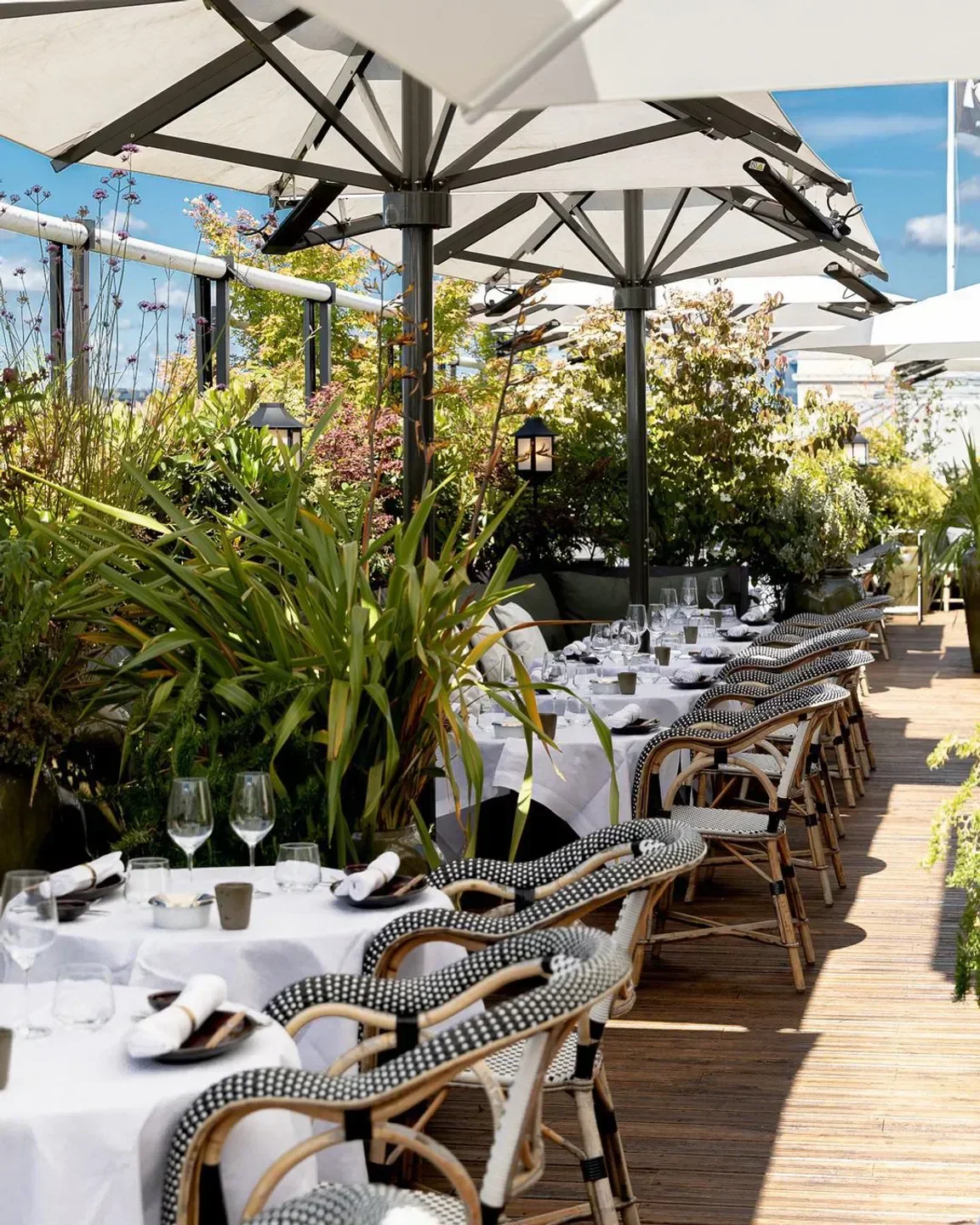 Rooftop dining at Mun in Paris, with stylish chairs and lush greenery.