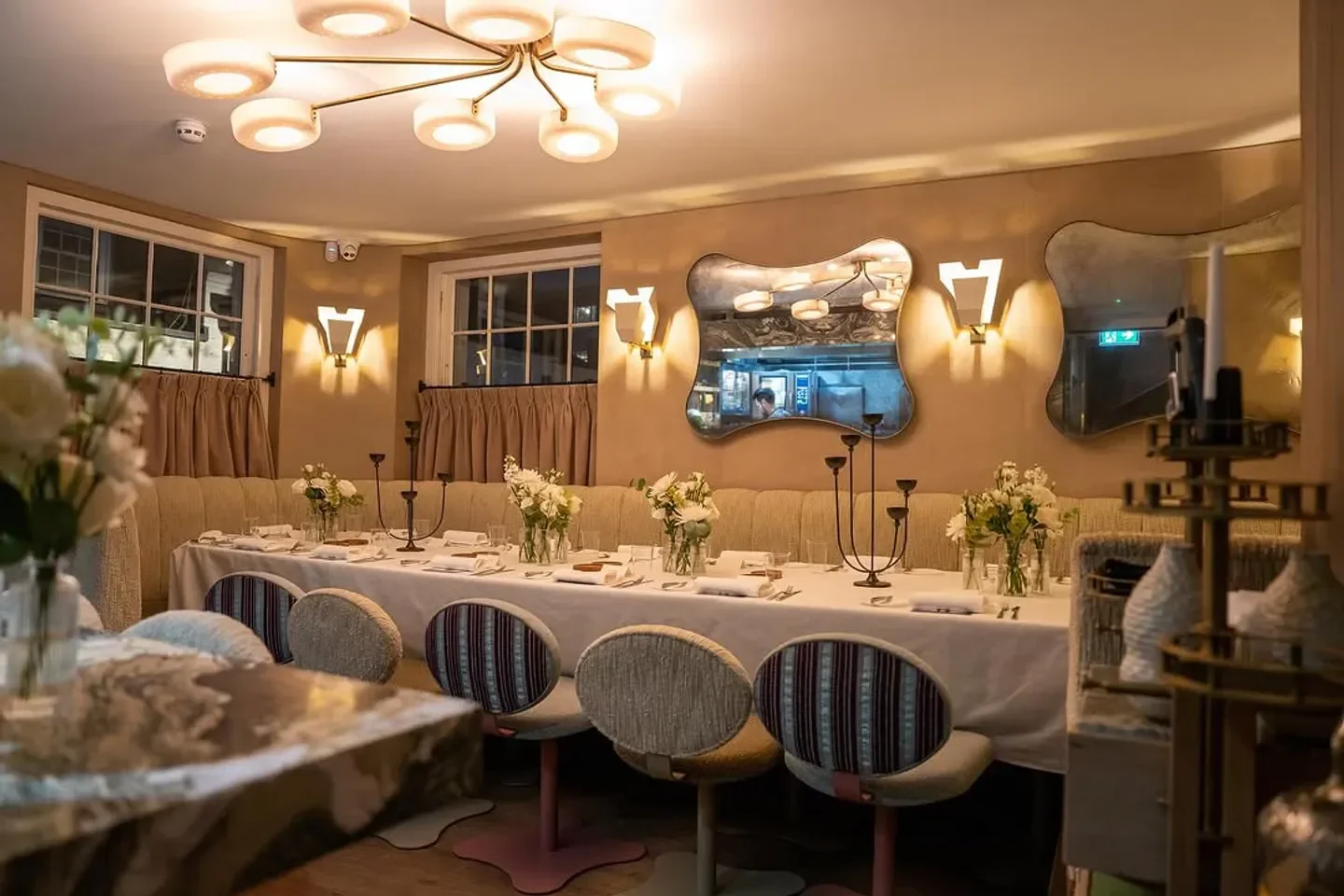 Interior dining at Muse restaurant in London, with a well-set table and elegant mirrors.