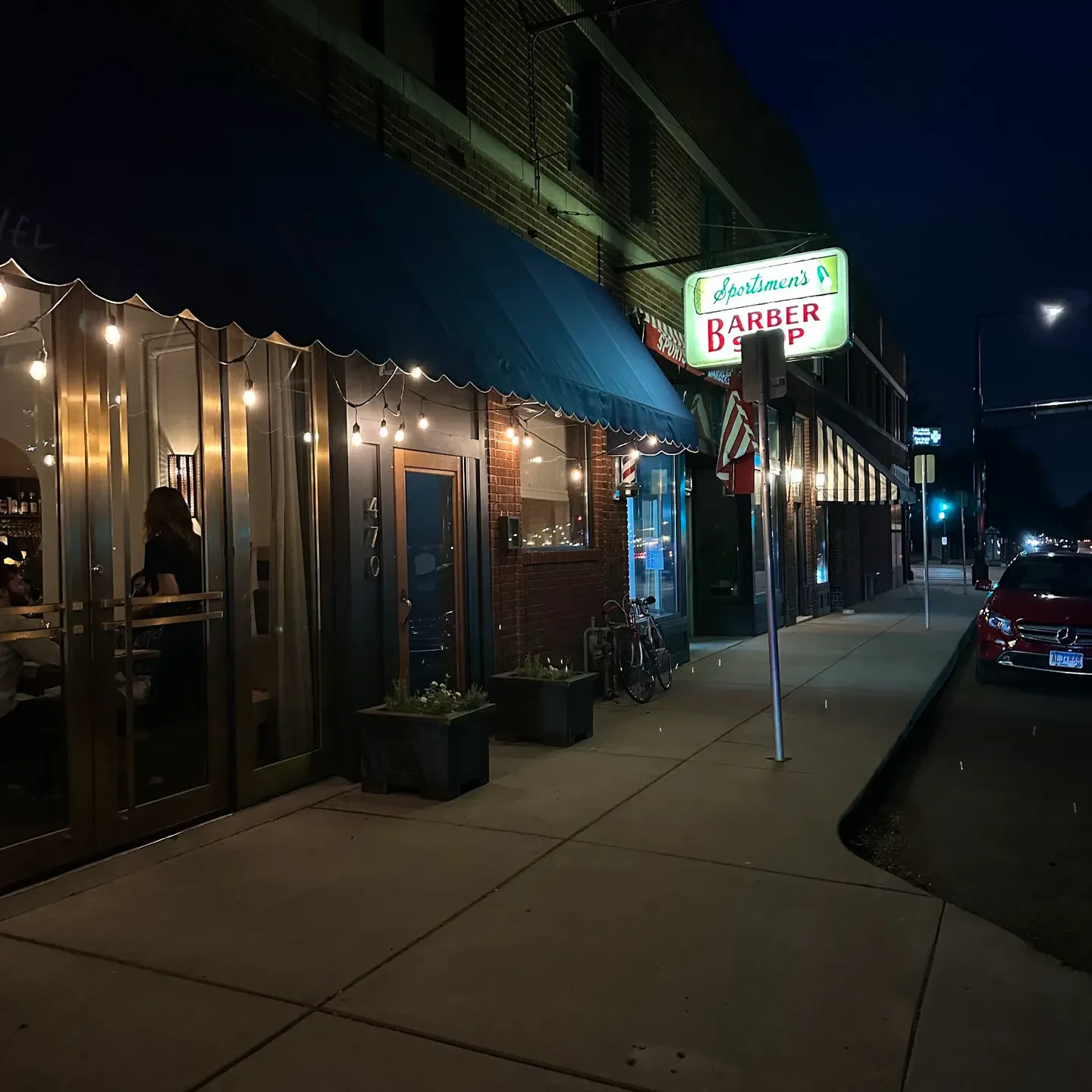Myriel restaurant in Minneapolis at night, alongside a vintage barber shop.