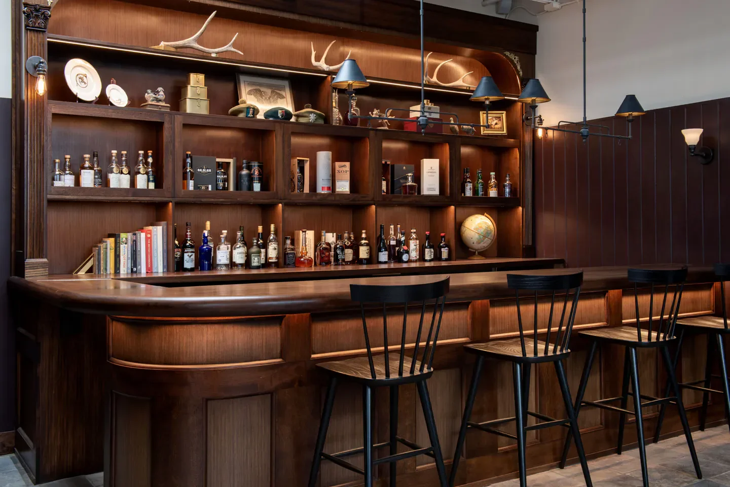 Cozy bar area at Nàdair restaurant in Atlanta, featuring wood shelving and decor.