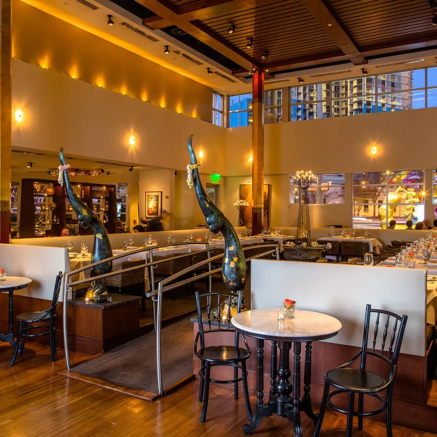 Elegant dining room at Nan Thai Fine Dining in Atlanta with sculptures and tables.