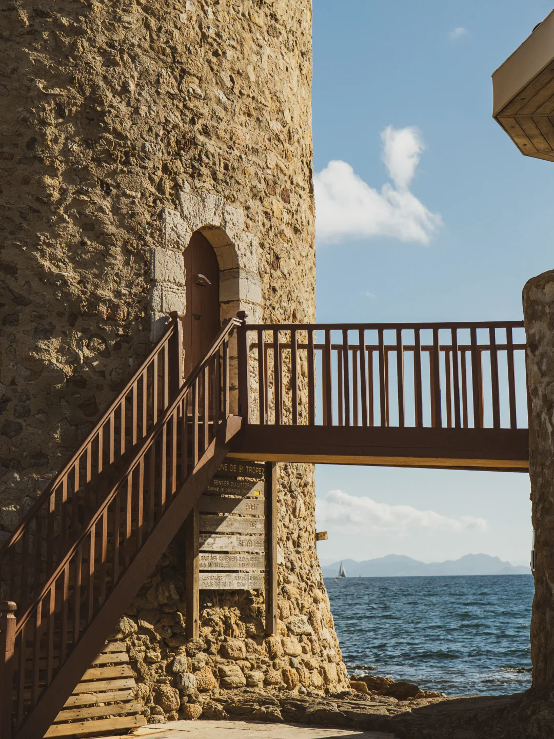 Exterior view of Nao restaurant in Saint-Tropez showcasing rustic stone architecture and coastal scenery.