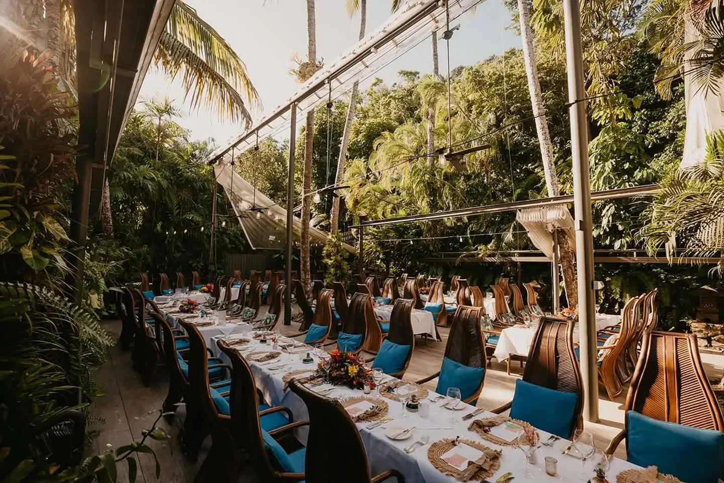 Outdoor dining at Nautilus Restaurant in Port Douglas, with lush tropical setting