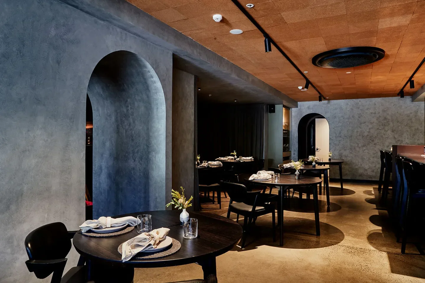 Interior of Navi restaurant in Melbourne with stylish tables and arched doorways.