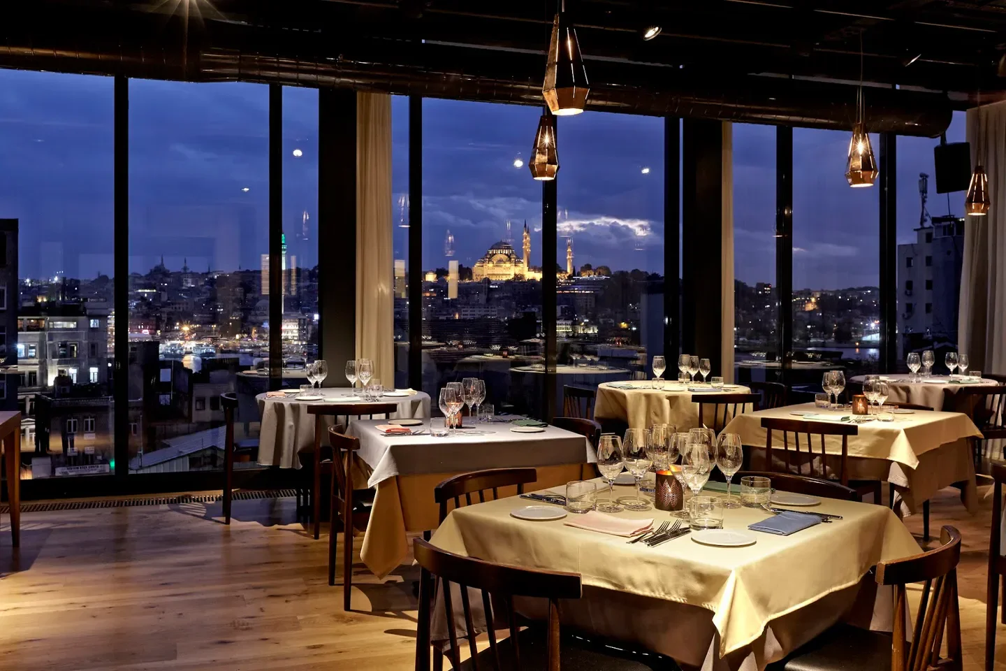 Elegant dining room at Neolokal in Istanbul with city views at dusk.