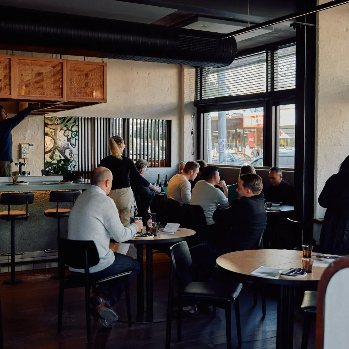 Stylish interior of New Quarter restaurant in Melbourne, with diners and bar seating.