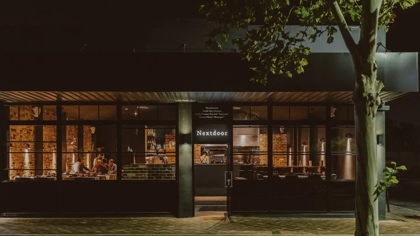 Nextdoor restaurant in Perth at night, featuring a stylish exterior and cozy ambiance.