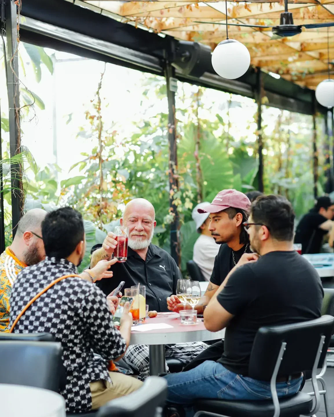 Group enjoying drinks at Nicos restaurant in Mexico City's stylish outdoor dining area.