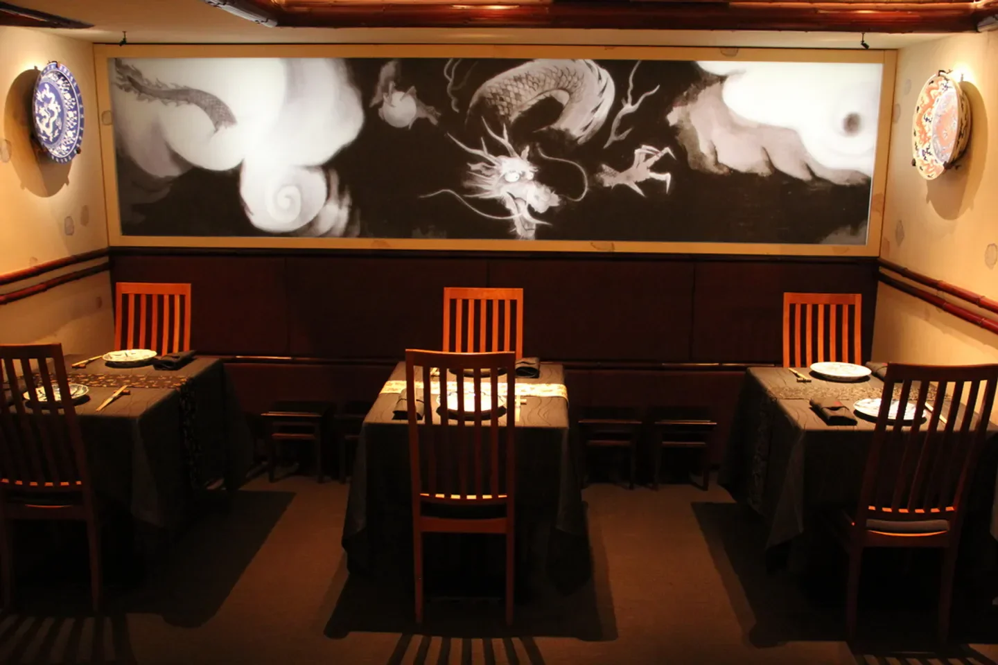 Elegant dining room interior at Nihonryori Ryugin restaurant in Tokyo with mural art.