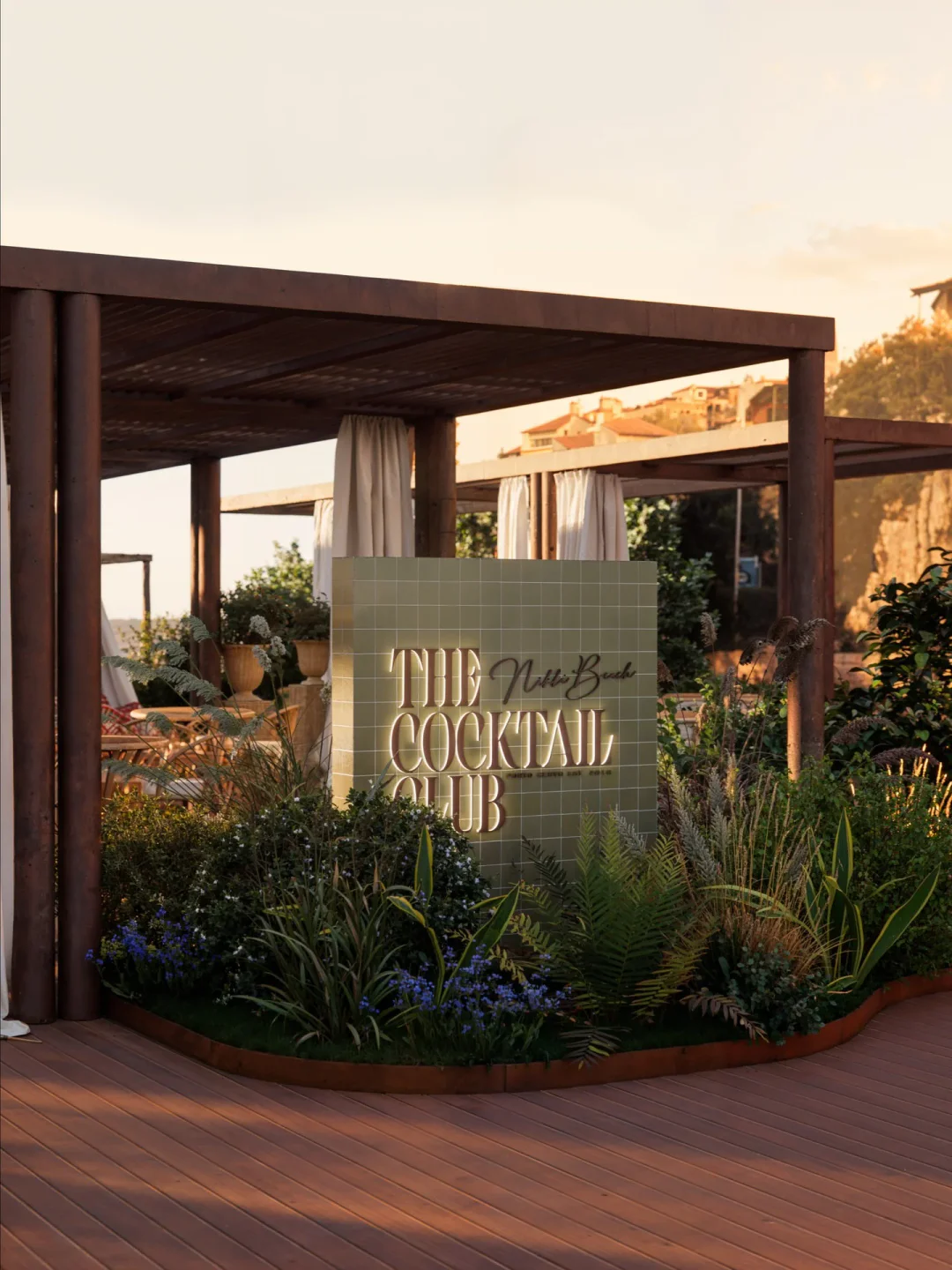 Nikki Beach Costa Smeralda entrance sign with lush greenery and wooden pergola