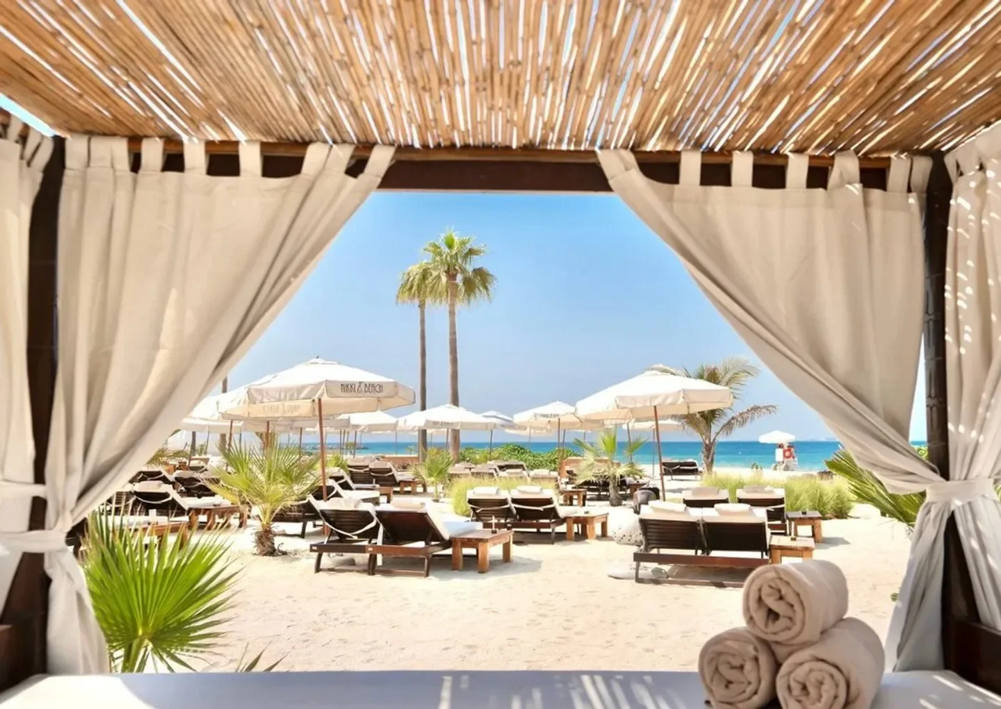 Relaxing beach scene at Nikki Beach Dubai, with lounge chairs and umbrellas.